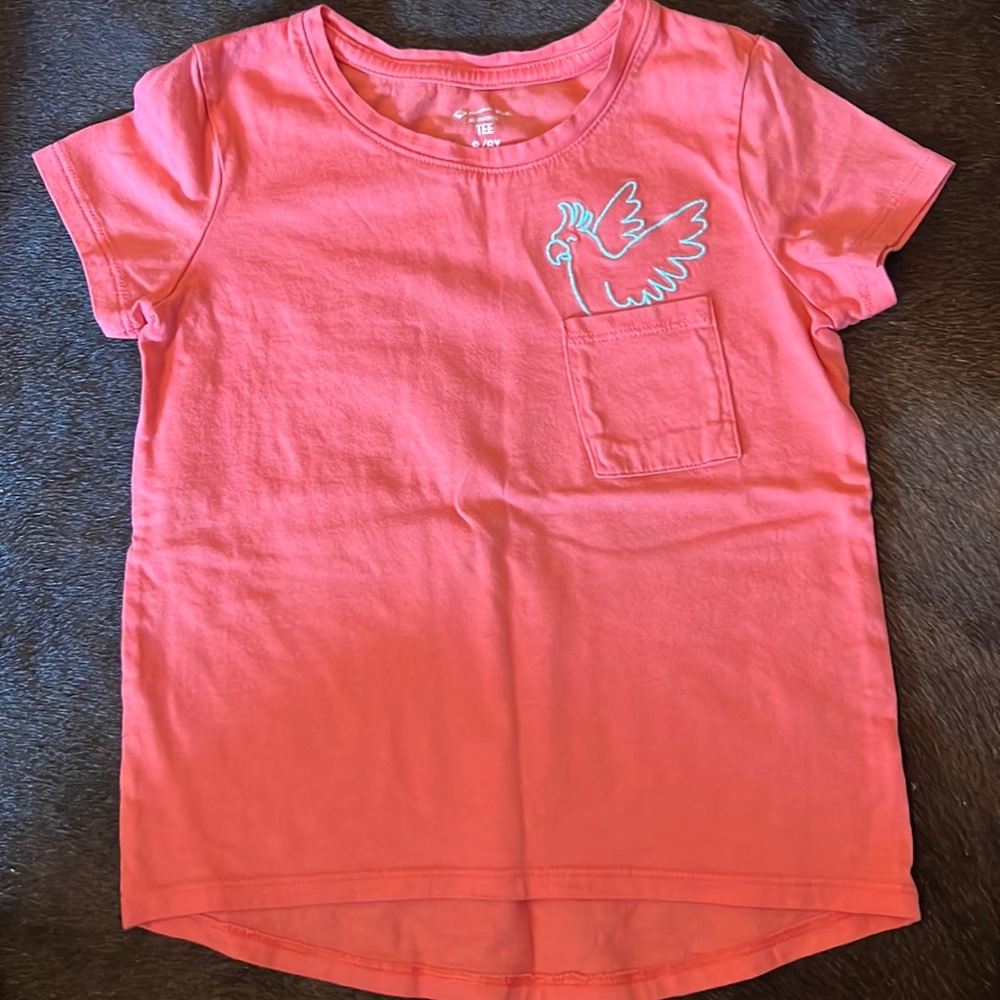 Pink shirt with pocket and parrot.